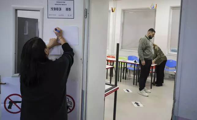 An electoral committee member prepares a voting station for a parliamentary election in Pristina, Kosovo, Sunday, Feb. 9, 2025. (AP Photo/Vlasov Sulaj)