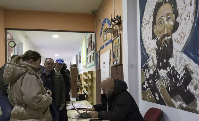 People wait in line during a parliamentary election at a polling station in the northern Serb-dominated part of ethnically divided town of Mitrovica, Kosovo, Sunday, Feb. 9, 2025. (AP Photo/Bojan Slavkovic)