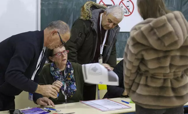 A voter waits for a ballot during a parliamentary election at a polling station in the northern Serb-dominated part of ethnically divided town of Mitrovica, Kosovo, Sunday, Feb. 9, 2025. (AP Photo/Bojan Slavkovic)