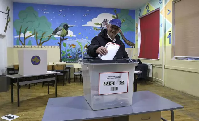 A man casts his ballot for a parliamentary election at a polling station in the northern Serb-dominated part of ethnically divided town of Mitrovica, Kosovo, Sunday, Feb. 9, 2025. (AP Photo/Bojan Slavkovic)