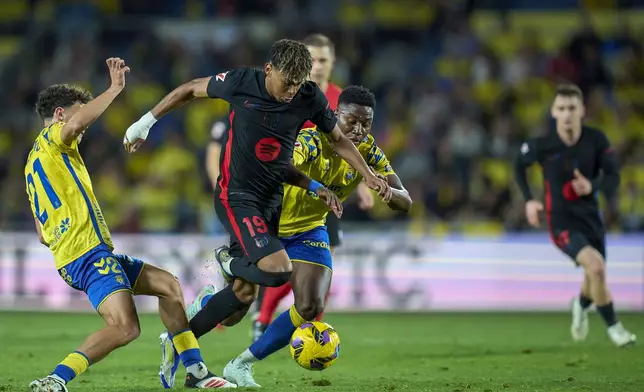 Barcelona's Lamine Yamal, second left, duels for the ball with Las Palmas' Stefan Bajcetic, left, during the Spanish La Liga soccer match between Las Palmas and Barcelona at the Gran Canaria stadium in Las Palmas, Spain's Canary Islands, Saturday, Feb. 22, 2024. (AP Photo/Gabriel Jimenez)