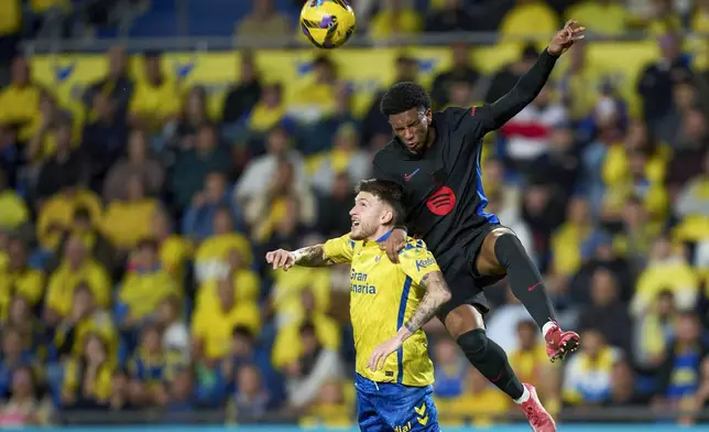 Barcelona's Alejandro Balde, right, duels for the ball with Las Palmas' Viti Rozada during the Spanish La Liga soccer match between Las Palmas and Barcelona at the Gran Canaria stadium in Las Palmas, Spain's Canary Islands, Saturday, Feb. 22, 2024. (AP Photo/Gabriel Jimenez)