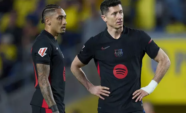 Barcelona's Robert Lewandowski, right, and Barcelona's Raphinha prepare for a free kick during the Spanish La Liga soccer match between Las Palmas and Barcelona at the Gran Canaria stadium in Las Palmas, Spain's Canary Islands, Saturday, Feb. 22, 2024. (AP Photo/Gabriel Jimenez)