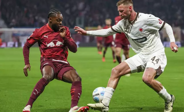 Leipzig's Ridle Baku, left, and St. Pauli's Siebe Van der Heyden fight for the ball during a Bundesliga soccer match in Leipzig, Germany, Sunday, Feb. 9, 2025. (Jan Woitas/dpa via AP)