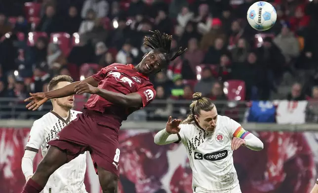 Leipzig's Amadou Haidara goes up for the ball against St. Pauli's Jackson Irvine during a Bundesliga soccer match in Leipzig, Germany, Sunday, Feb. 9, 2025. (Jan Woitas/dpa via AP)