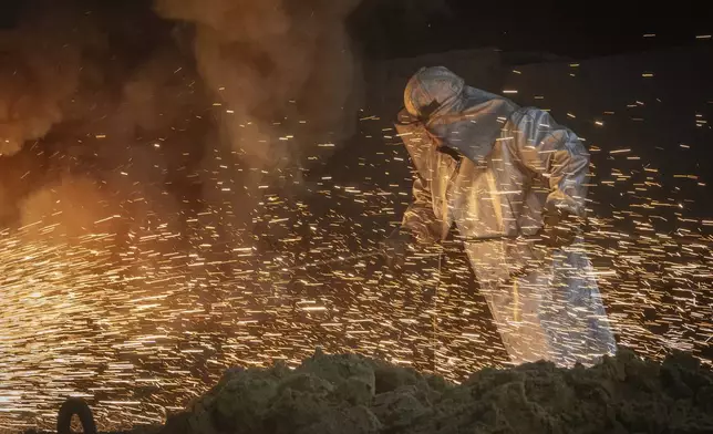 A worker in protective clothes melts steel at the Zaporizhstal Iron and Steelworks, one of the country's largest steel plants, in Zaporizhzhia, Ukraine, Thursday, Feb. 13, 2025. (AP Photo/Efrem Lukatsky)
