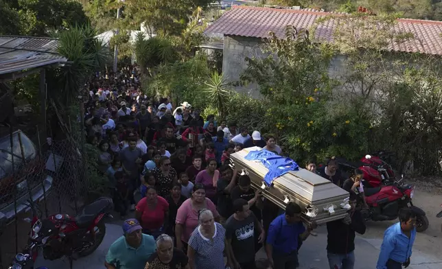 Pallbearers carry the coffin of a victim of a bus crash to a cemetery for burial in Santo Domingo Los Ocotes, Guatemala, Tuesday, Feb. 11, 2025, the day after dozens of passengers died when the bus they were traveling on plunged into a gorge on the outskirts of Guatemala City.. (AP Photo/Moises Castillo)