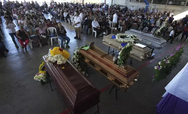 Mourners attend a funeral service for the victims of a bus crash, in Santo Domingo Los Ocotes, Guatemala, Tuesday, Feb. 11, 2025. Dozens of passengers died after their bus plunged into a gorge and landed under a bridge on Feb. 10 on the outskirts of the Guatemalan capital. (AP Photo/Moises Castillo)