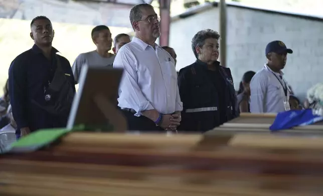 Guatemalan President Bernardo Arévalo, center, and first lady Lucrecia Peinado, pay their final respects to the victims of a bus crash, at a funeral service in Santo Domingo Los Ocotes, Guatemala, Tuesday, Feb. 11, 2025. Dozens of passengers died after their bus plunged into a gorge and landed under a bridge on Feb. 10 on the outskirts of the Guatemalan capital. (AP Photo/Moises Castillo)