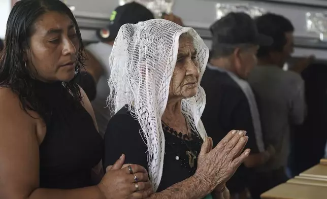 Mourners pay their final respects to the victims of a bus crash at a funeral service in Santo Domingo Los Ocotes, Guatemala, Tuesday, Feb. 11, 2025. Dozens of passengers died after their bus plunged into a gorge and landed under a bridge on Feb. 10 on the outskirts of the Guatemalan capital. (AP Photo/Moises Castillo)