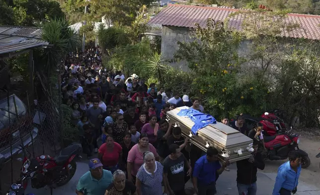 Pall bearers carry a coffin that contains the remains of a victim of a bus crash, to a cemetery for a burial service in Santo Domingo Los Ocotes, Guatemala, Tuesday, Feb. 11, 2025. Dozens of passengers died after their bus plunged into a gorge and landed under a bridge on Feb. 10 on the outskirts of the Guatemalan capital. (AP Photo/Moises Castillo)