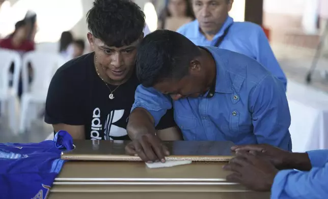 Mourners pay their final respects to the victim of a bus crash at a funeral service in Santo Domingo Los Ocotes, Guatemala, Tuesday, Feb. 11, 2025. Dozens of passengers died after their bus plunged into a gorge and landed under a bridge on Feb. 10 on the outskirts of the Guatemalan capital. (AP Photo/Moises Castillo)