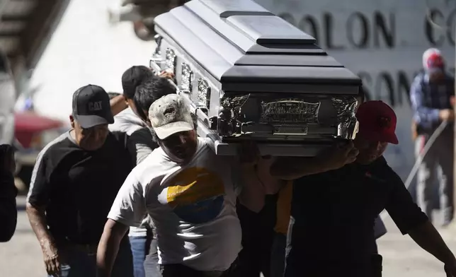 Pall bearers carry a coffin that contains the remains of a victim of a bus crash, at a funeral service in Santo Domingo Los Ocotes, Guatemala, Tuesday, Feb. 11, 2025. Dozens of passengers died after their bus plunged into a gorge and landed under a bridge on Feb. 10 on the outskirts of the Guatemalan capital. (AP Photo/Moises Castillo)
