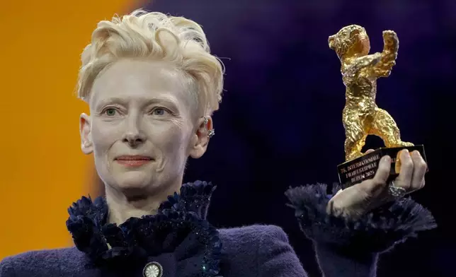 Tilda Swinton holds the honorary Golden Bear for her life work during the opening of the International Film Festival, Berlinale, in Berlin, Thursday, Feb. 13, 2025. (AP Photo/Markus Schreiber)