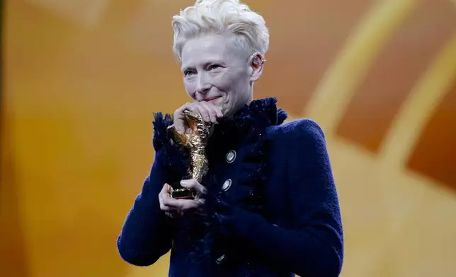 Tilda Swinton holds the honorary Golden Bear for her lifetime achievement during the opening of the International Film Festival, Berlinale, in Berlin, Thursday, Feb. 13, 2025. (AP Photo/Markus Schreiber)