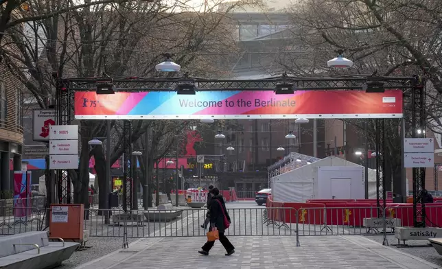 People walk past posters of the 75th Berlinale International Film Festival, in Berlin, Germany, Wednesday, Feb. 12, 2025. (AP Photo/Ebrahim Noroozi)