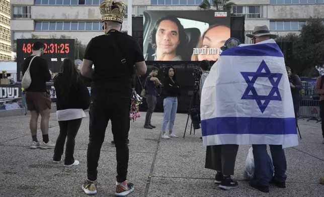 Israelis watch a broadcast of the release of Israelis Ofer Kalderon, 53, and Yarden Bibas, 34, and American-Israeli Keith Siegel, 65 set to be released as part of a ceasefire in the Gaza Strip, in Tel Aviv, Israel, Saturday Feb. 1, 2025. (AP Photo/Oded Balilty3