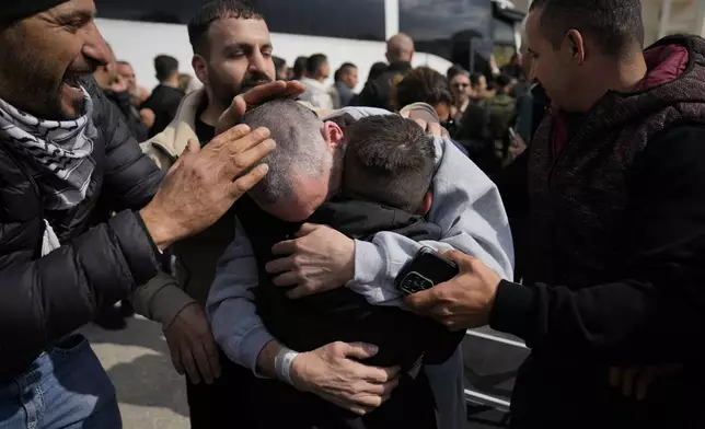 Palestinian prisoners are greeted as they exit a Red Cross bus after being released from Israeli prison following a ceasefire agreement between Israel and Hamas, in the West Bank city of Ramallah, Saturday Feb. 1, 2025. (AP Photo/Nasser Nasser)