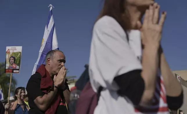 Israelis react as they watch a broadcast of the release of American-Israeli Keith Siegel, as he is released as part of a ceasefire in the Gaza Strip, in Tel Aviv, Israel, Saturday Feb. 1, 2025. (AP Photo/Oded Balilty)
