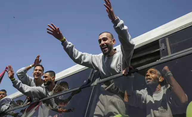 Freed Palestinian prisoners wave from a bus as they arrive in the Gaza Strip after being released from an Israeli prison following a ceasefire agreement between Hamas and Israel in Khan Younis, Saturday, Feb. 1, 2025. (AP Photo/Jehad Alshrafi)