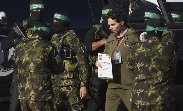 Israeli Ofer Kalderon who has been held hostage by Hamas in Gaza since October 7, 2023, walks next to Hamas fighters before being handed over to the Red Cross by Hamas fighters in Khan Younis, southern Gaza Strip, Saturday Feb. 1, 2025. Photo/Abdel Kareem)