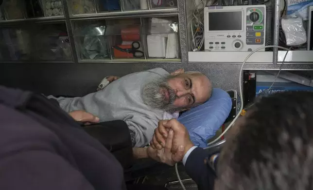 Palestinian prisoner Hussam Shaheen is greeted as he is taken in an ambulance for a medical check after being released from an Israeli prison following a ceasefire agreement between Israel and Hamas, in the West Bank city of Ramallah, Saturday Feb. 1, 2025. (AP Photo/Mahmoud Illean)