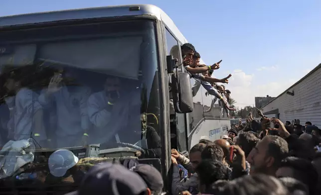 Freed Palestinian prisoners are greeted by a crowd as they arrive in the Gaza Strip after being released from an Israeli prison following a ceasefire agreement between Hamas and Israel in Khan Younis, Saturday, Feb. 1, 2025. (AP Photo/Jehad Alshrafi)