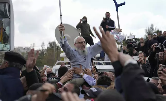 Palestinian prisoners are greeted as they exit a Red Cross bus after being released from Israeli prison following a ceasefire agreement between Israel and Hamas, in the West Bank city of Ramallah, Saturday Feb. 1, 2025. (AP Photo/Nasser Nasser)