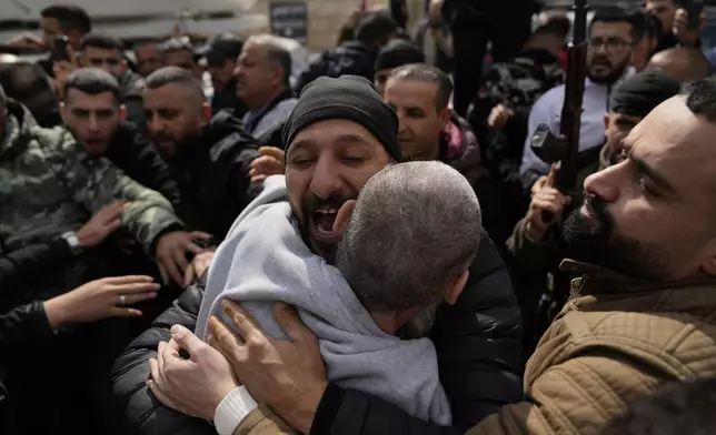 Palestinian prisoners are greeted as they exit a Red Cross bus after being released from Israeli prison following a ceasefire agreement between Israel and Hamas, in the West Bank city of Ramallah, Saturday Feb. 1, 2025. (AP Photo/Nasser Nasser)