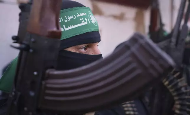 FILE - A member of the Islamic Jihad group holds his weapon as Israeli hostages are escorted to be handed over to the Red Cross in Khan Younis, southern Gaza Strip, Thursday Jan. 30, 2025. (AP Photo/Abdel Kareem Hana, File)