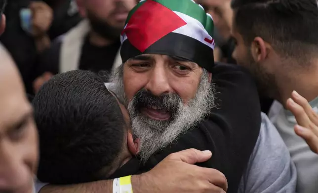 A Palestinian prisoner wearing a Palestinian flag headband is greeted as he exits a Red Cross bus after being released from Israeli prison following a ceasefire agreement between Israel and Hamas, in the West Bank city of Ramallah, Saturday, Feb. 1, 2025. (AP Photo/Nasser Nasser)