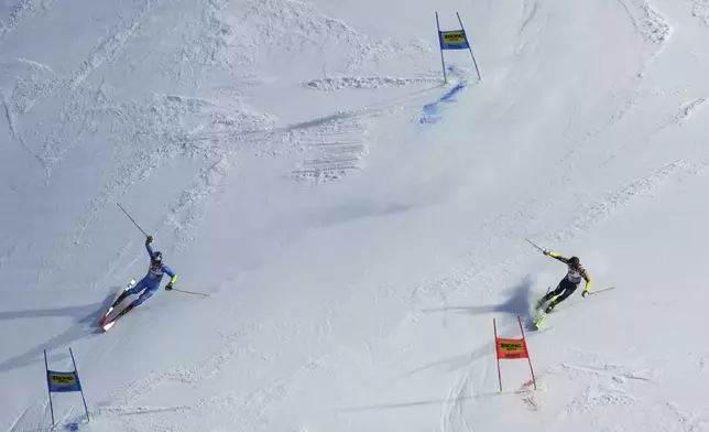 Italy's Alex Vinatzer, left, and Sweden's Kristoffer Jakobsen speed down the course during an alpine ski, World Championship team parallel event, in Saalbach-Hinterglemm, Austria, Tuesday, Feb. 4, 2025. (AP Photo/Giovanni Auletta)