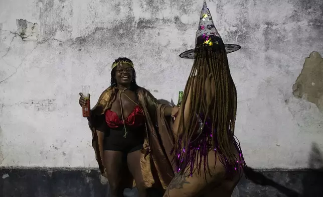 Celia Regina, left, dances with a sex worker during a pre-Carnival block party in the Vila Mimosa red-light district in Rio de Janeiro, Friday, Feb. 21, 2025. Sex workers, and supporters paraded in the block party, demanding attention to their problems, such as better health, safety and visibility. (AP Photo/Bruna Prado)