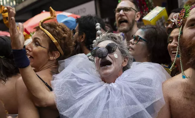 A reveler dressed as a Pierrot sings during the "Cordao do Boitata" street pre-carnival party in Rio de Janeiro, Sunday, Feb. 23, 2025. (AP Photo/Bruna Prado)
