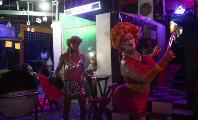 Lucci Souza, right, performs during a street pre-Carnival block party in the Vila Mimosa red-light district in Rio de Janeiro, Friday, Feb. 21, 2025. Sex workers, and supporters paraded in the block party, demanding attention to their problems, such as better health, safety and visibility. (AP Photo/Bruna Prado)