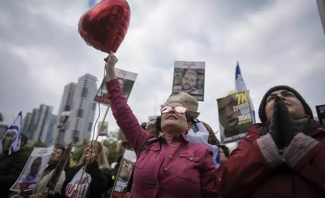 Israelis watch on a live broadcast as the first two of six hostages to be released in Gaza by Palestinian militants are handed over to the Red Cross, in 'Hostages Square' in Tel Aviv, Israel, Saturday Feb. 22, 2025. (AP Photo/Oded Balilty)