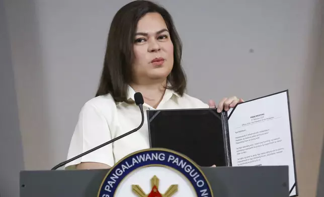 Philippine Vice President Sara Duterte holds a copy of her statement as she speaks during a press conference in Manila, Philippines on Friday, Feb. 7, 2025. (AP Photo/Basilio Sepe)