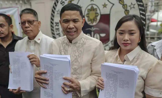 Philippine Vice President Sara Duterte's lawyers, from left, Atty. Martin Delgra, Atty. Israelito Torreon and Atty. Hillary Olga shows documents they filed asking the 15-member high court to annul her impeachment and block the trial at the Supreme Court in Manila, Philippines Tuesday, Feb. 18, 2025. (AP Photo/Gerard Carreon)