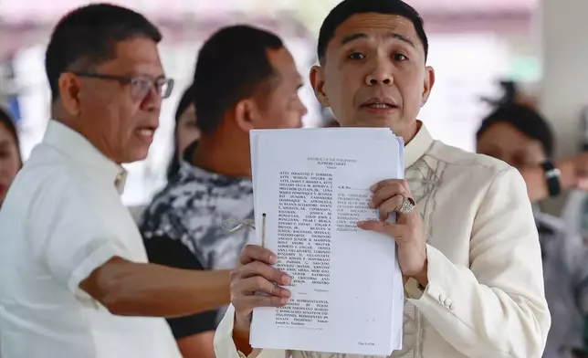 Philippine Vice President Sara Duterte's lawyer Israelito Torreon, right, shows documents they filed asking the 15-member high court to annul her impeachment and block the trial at the Supreme Court in Manila, Philippines Tuesday, Feb. 18, 2025. (AP Photo/Gerard Carreon)