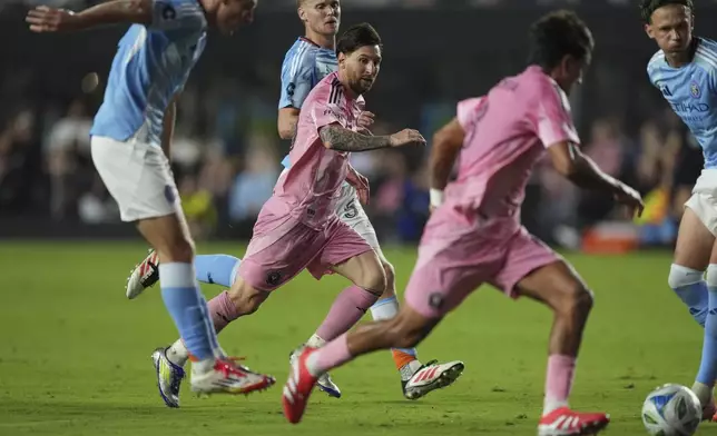 Inter Miami forward Lionel Messi, center, passes to midfielder Telasco Segovia to score the side's second goal against New York City FC, tying the game in the final minutes of stoppage time in their MLS soccer match, Saturday, Feb. 22, 2025, in Fort Lauderdale, Fla. (AP Photo/Rebecca Blackwell)