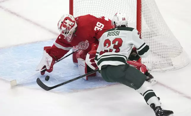 Minnesota Wild center Marco Rossi (23) scores on Detroit Red Wings goaltender Cam Talbot (39) in overtime of an NHL hockey game Saturday, Feb. 22, 2025, in Detroit. (AP Photo/Paul Sancya)