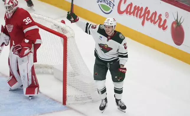 Minnesota Wild center Marco Rossi (23) celebrates scoring on Detroit Red Wings goaltender Cam Talbot (39) in overtime of an NHL hockey game Saturday, Feb. 22, 2025, in Detroit. (AP Photo/Paul Sancya)