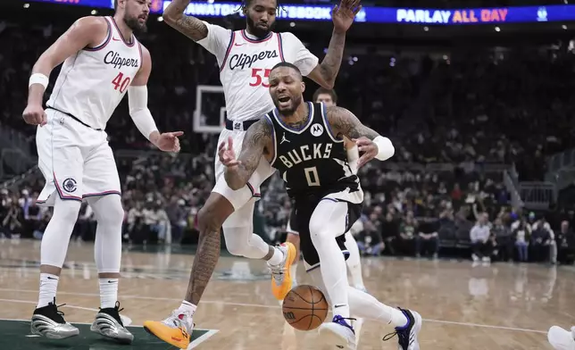 Milwaukee Bucks' Damian Lillard loses the ball in front of LA Clippers' Derrick Jones Jr. and Ivica Zubac during the first half of an NBA basketball game Thursday, Feb. 20, 2025, in Milwaukee. (AP Photo/Morry Gash)