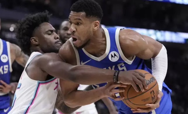 Milwaukee Bucks' Giannis Antetokounmpo is fouled by Miami Heat's Davion Mitchell during the second half of an NBA basketball game Sunday, Feb. 23, 2025, in Milwaukee. (AP Photo/Morry Gash)