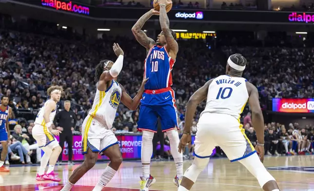 Sacramento Kings forward DeMar DeRozan, center, goes up to shoot a basket over Golden State Warriors guard Buddy Hield (7) during the first half of an NBA basketball game Friday, Feb. 21, 2025, in Sacramento, Calif. (AP Photo/Sara Nevis)