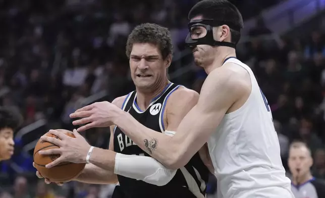 Milwaukee Bucks' Brook Lopez tries to get past Memphis Grizzlies' Zach Edey during the first half of an NBA basketball game Sunday, Feb. 2, 2025, in Milwaukee. (AP Photo/Morry Gash)