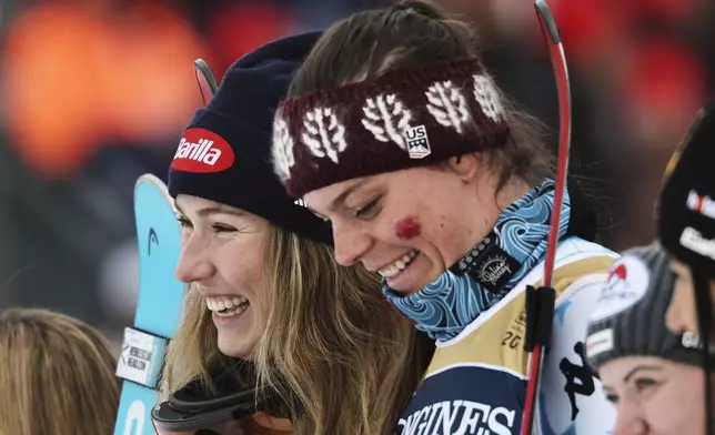 United States' Mikaela Shiffrin, left, and teammate United States' Breezy Johnson celebrate on the podium after winning the gold medal in a women's team combined event, at the Alpine Ski World Championships, in Saalbach-Hinterglemm, Austria, Tuesday, Feb. 11, 2025. (AP Photo/Marco Trovati)