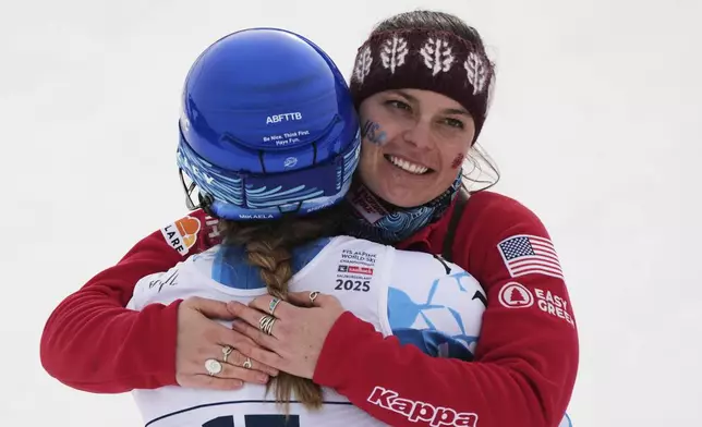 United States' Breezy Johnson, right, hugs teammate. United States' Mikaela Shiffrin at the finish area of a slalom run of a women's team combined event, at the Alpine Ski World Championships, in Saalbach-Hinterglemm, Austria, Tuesday, Feb. 11, 2025. (AP Photo/Giovanni Auletta)