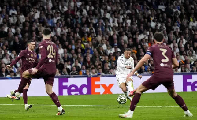 Real Madrid's Kylian Mbappe shoots to score his sides third goal during the Champions League playoff second leg soccer match between Real Madrid and Manchester City at the Santiago Bernabeu Stadium in Madrid, Spain, Wednesday, Feb. 19, 2025. (AP Photo/Manu Fernandez)
