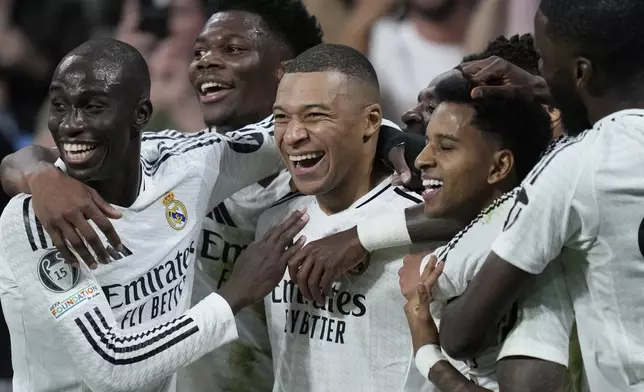 Real Madrid's Kylian Mbappe, center, celebrates after scoring his side's second goal during the Champions League playoff second leg soccer match between Real Madrid and Manchester City at the Santiago Bernabeu Stadium in Madrid, Spain, Wednesday, Feb. 19, 2025. (AP Photo/Bernat Armangue)